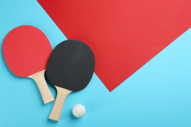 Ping pong rackets and ball on color background, flat lay. Space for text