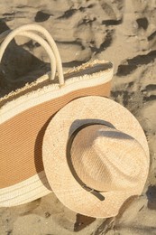 Photo of Stylish bag and hat on sand. Beach accessories