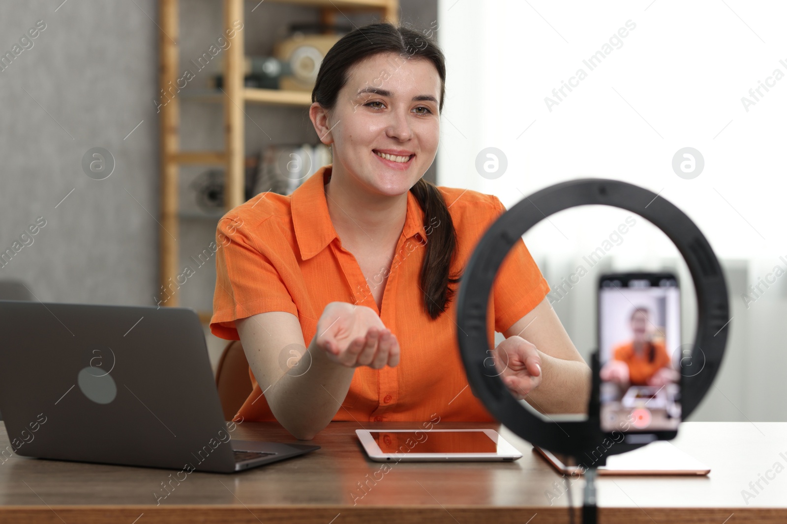 Photo of Smiling technology blogger with tablets recording video review at home