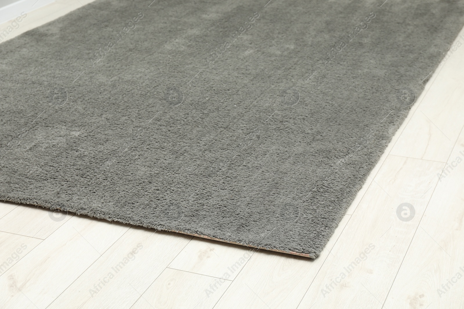 Photo of Soft grey carpet on white laminated floor indoors