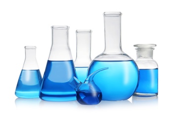 Photo of Set of laboratory glassware with blue liquid on white background