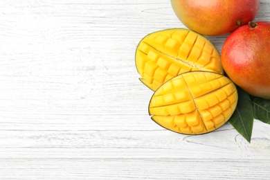 Photo of Flat lay composition with mango on white wooden background. Space for text