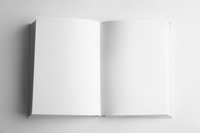 Photo of Open book with blank pages on white background, top view. Mock up for design