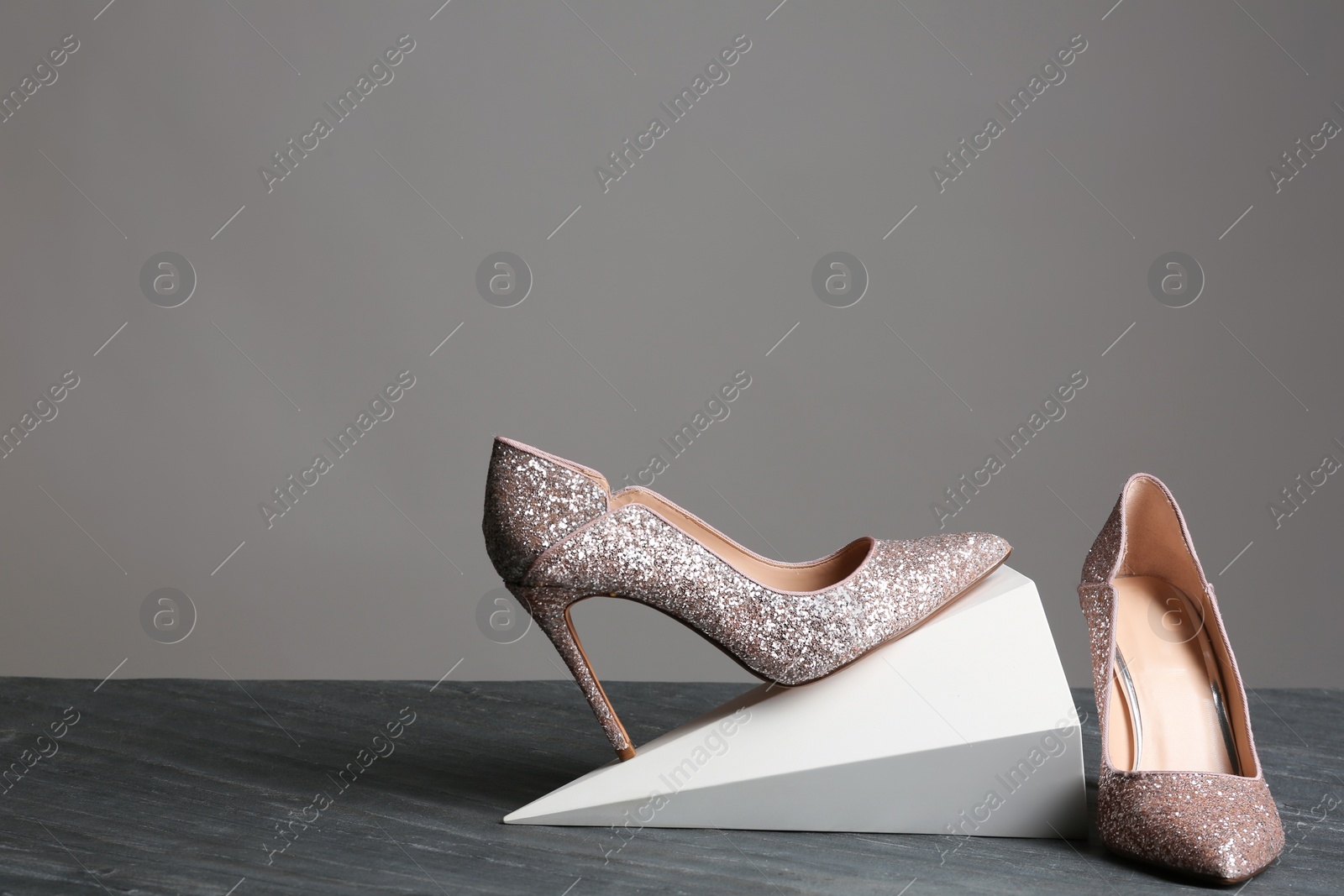 Photo of Composition with elegant female shoes on table against grey background. Space for text