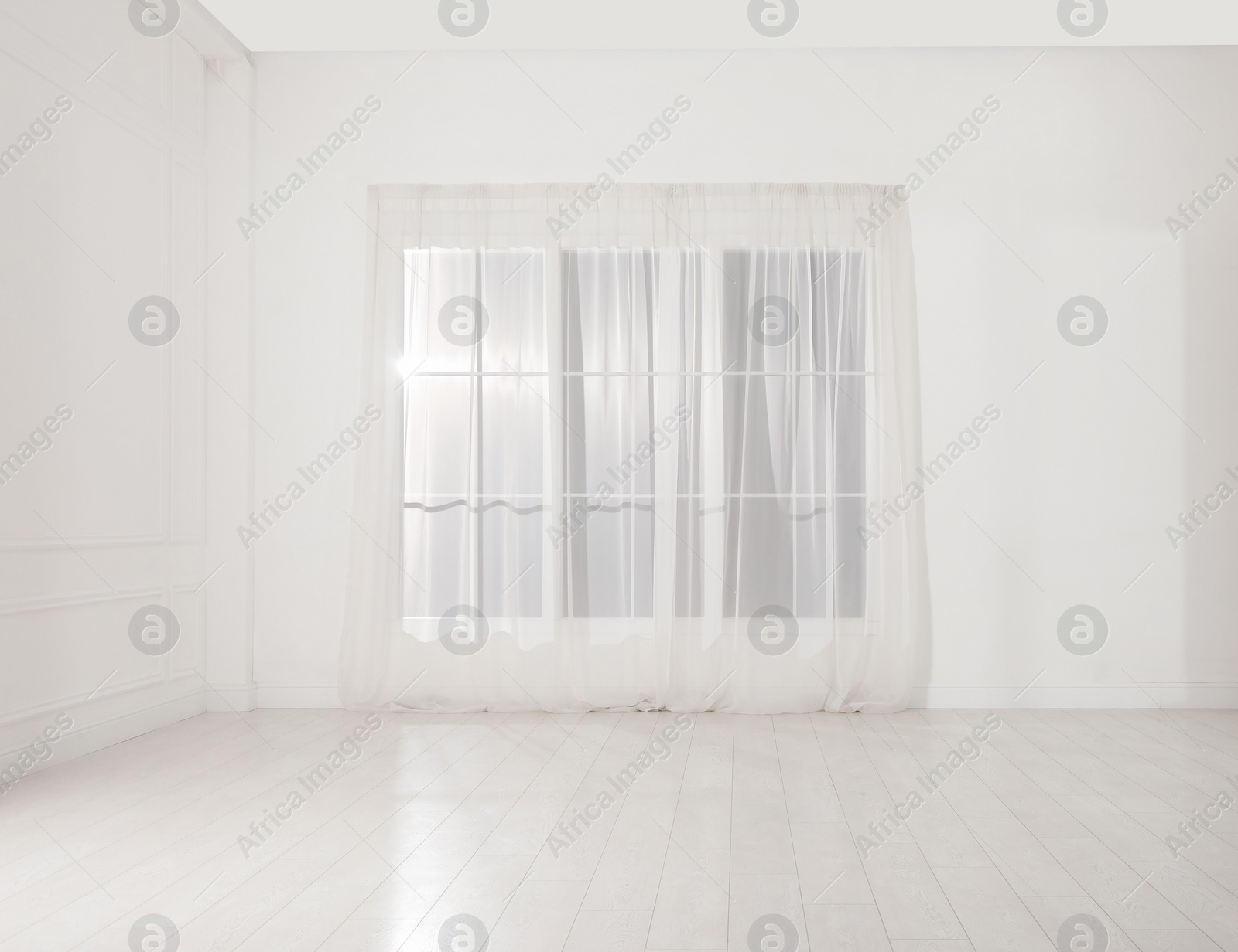 Photo of Empty room with white walls and large window