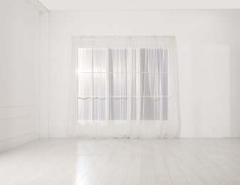 Photo of Empty room with white walls and large window