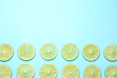 Fresh juicy lime slices on light blue background, flat lay. Space for text