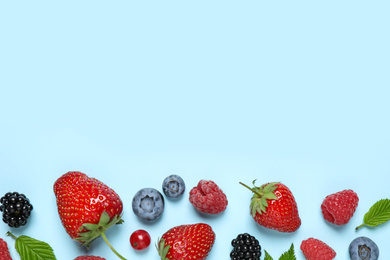 Photo of Different fresh berries on light blue background, flat lay. Space for text