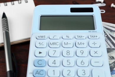 Photo of Calculator, notebook and pen on table, closeup. Retirement concept