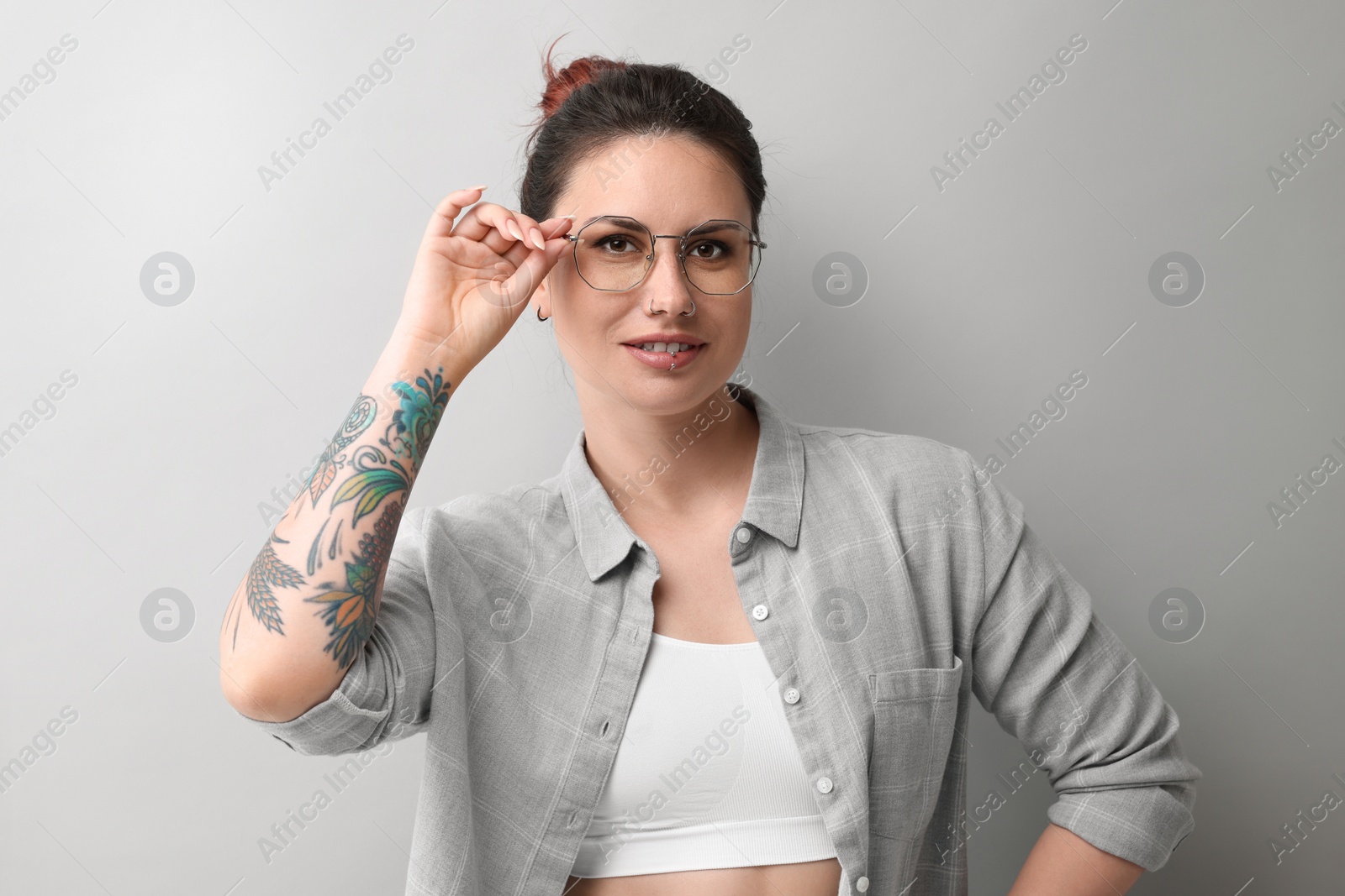 Photo of Portrait of beautiful tattooed woman on gray background