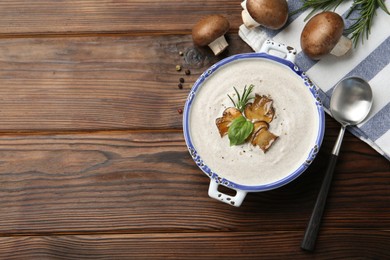 Photo of Delicious homemade mushroom soup served on wooden table, flat lay. Space for text