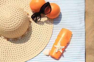 Photo of Beach accessories and oranges on sand, flat lay
