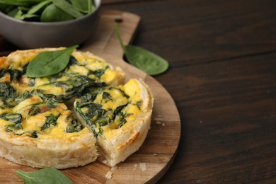 Photo of Delicious pie with spinach on wooden table, closeup