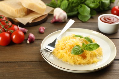 Photo of Tasty spaghetti squash with basil and cheese served on wooden table