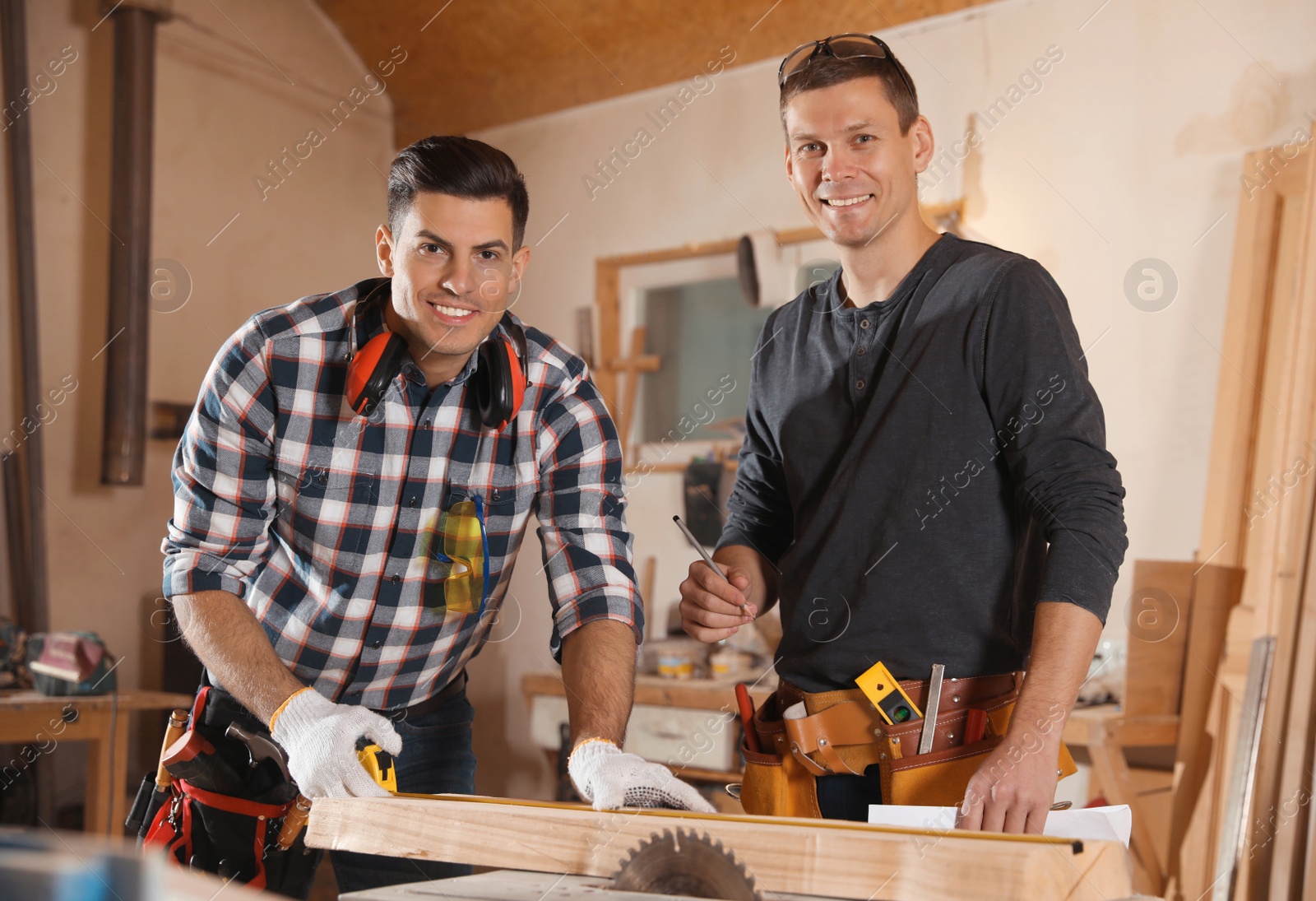 Photo of Professional carpenters working with sawmill machine in workshop