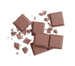 Pieces of delicious milk chocolate bar on white background, top view