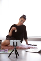 Young blogger recording video on floor at home