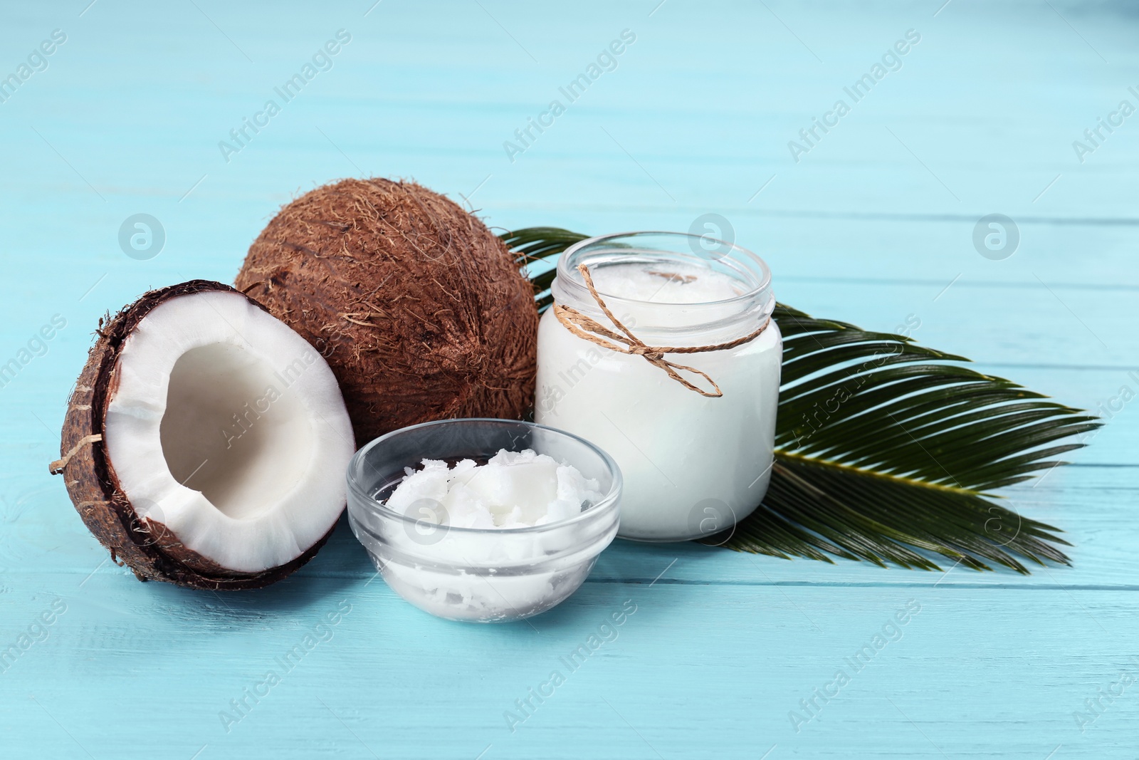 Photo of Composition with organic coconut oil on light blue wooden table. Healthy cooking