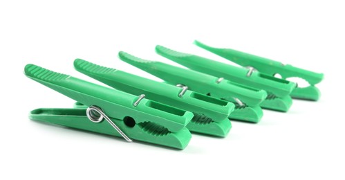 Bright green plastic clothespins on white background