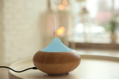 Aroma oil diffuser on table indoors