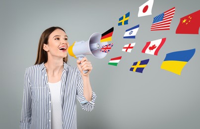 Image of Portrait of interpreter with megaphone and flags of different countries on grey background