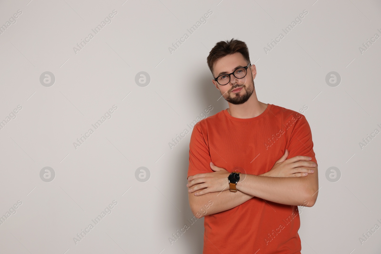 Photo of Handsome man in eyeglasses on light grey background, space for text