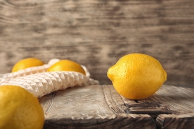 Wooden board with lemon on table