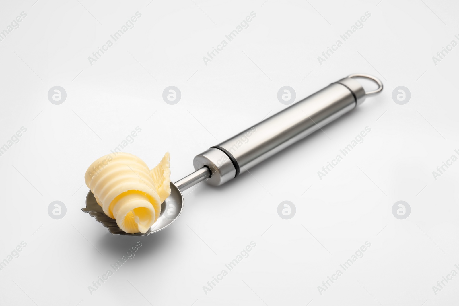 Photo of Knife with butter curl on white background