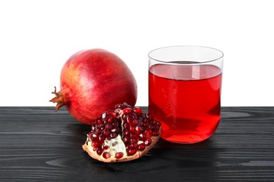 Photo of Refreshing pomegranate juice in glass and fruits on black wooden table against white background
