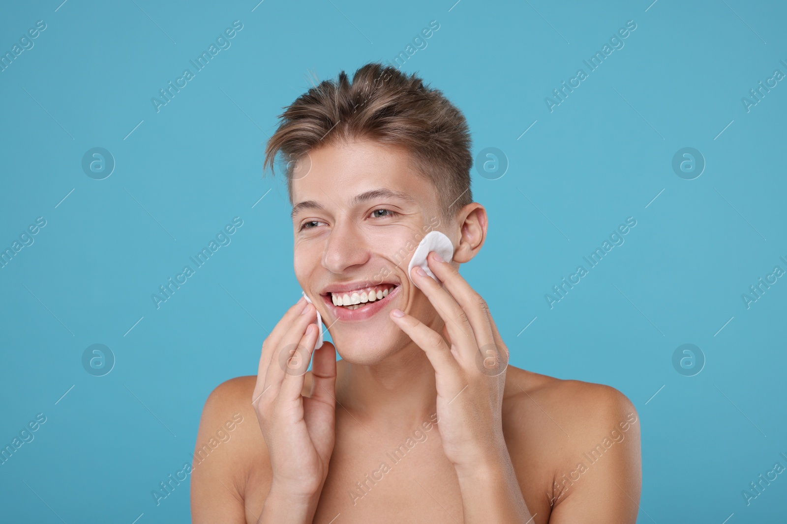 Photo of Handsome man with cotton pads on light blue background