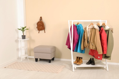 Photo of Stylish hallway interior with clothes on hanger stand