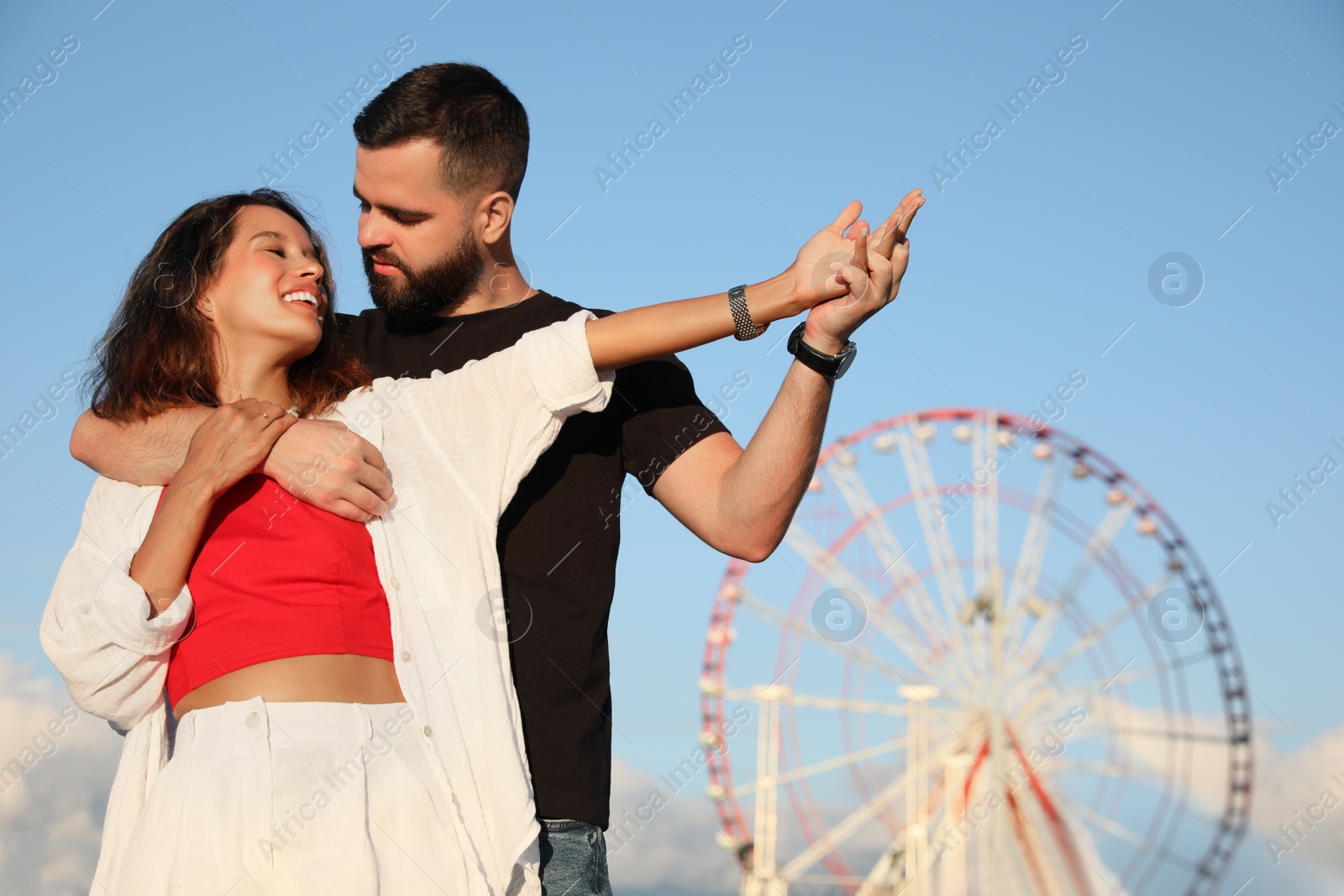Photo of Happy young couple hugging in amusement park