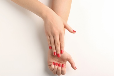 Photo of Woman with red manicure on white background, top view. Nail polish trends
