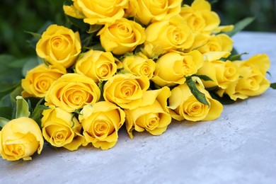 Photo of Beautiful bouquet of yellow roses on light table, closeup