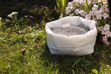 Photo of Fertilizer in bag on green grass outdoors