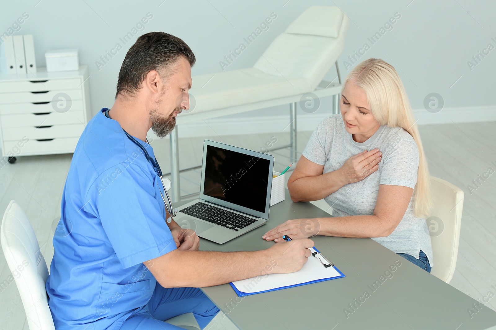 Photo of Male medical assistant consulting female patient in clinic