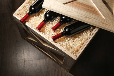Photo of Wooden crate with bottles of wine on floor