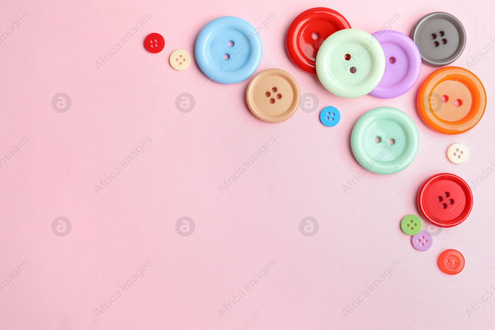 Photo of Many sewing buttons on pink background, flat lay. Space for text