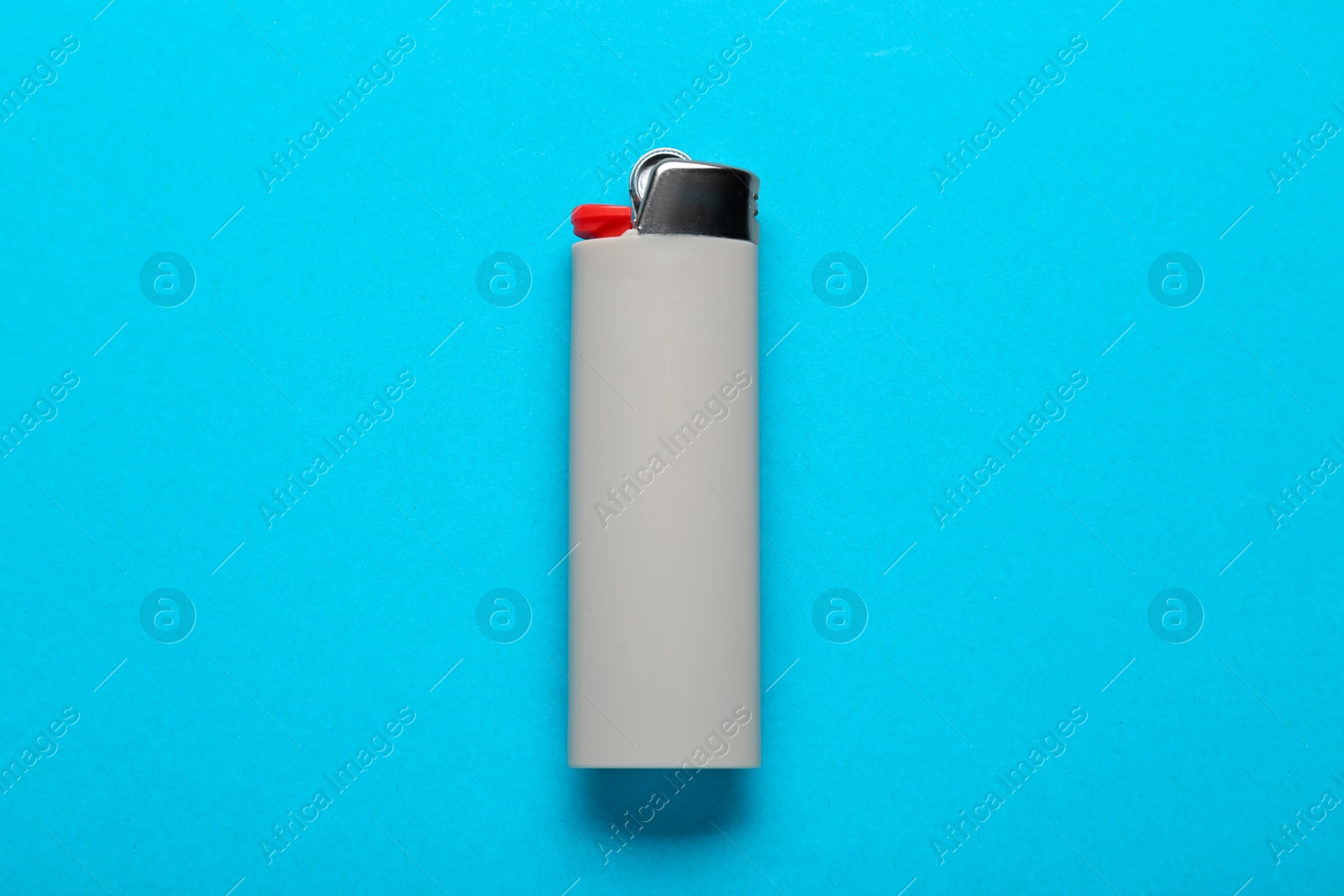 Photo of Gray plastic cigarette lighter on light blue background, top view