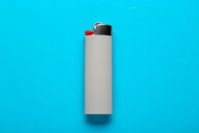 Photo of Gray plastic cigarette lighter on light blue background, top view