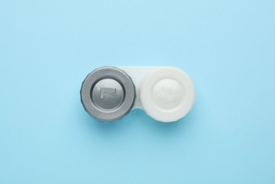 Photo of Case with contact lenses on light blue background, top view