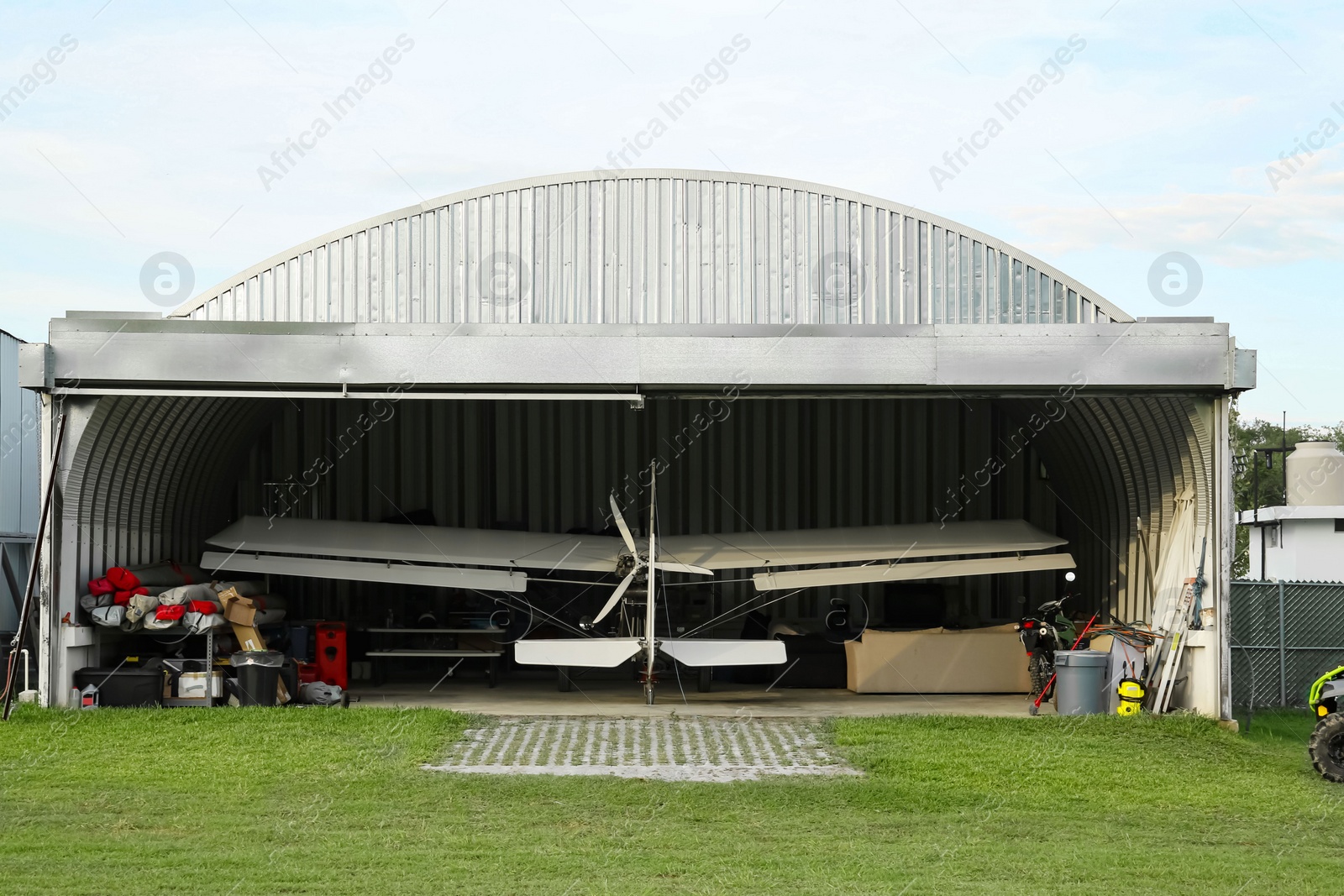 Photo of Modern white airplane in big hangar on sunny day