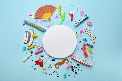 Flat lay composition with carnival items and blank card on light blue background. Space for text