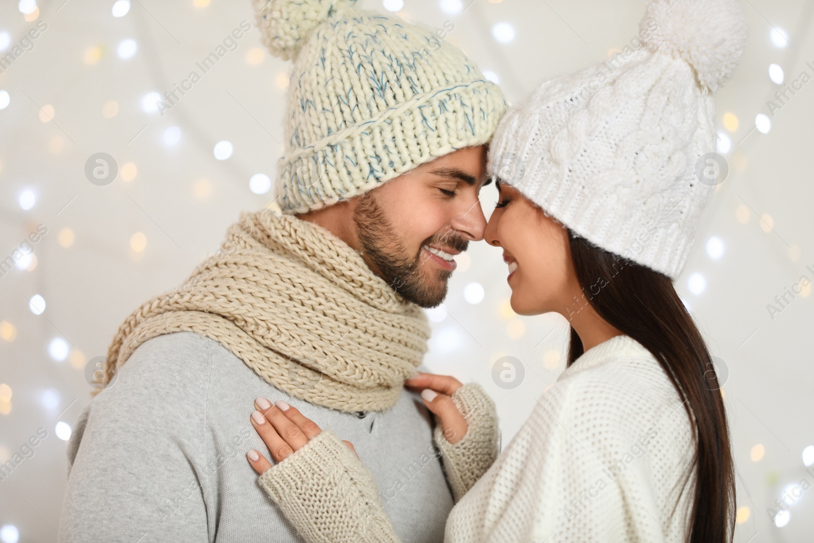 Photo of Lovely young couple against blurred festive lights. Christmas celebration