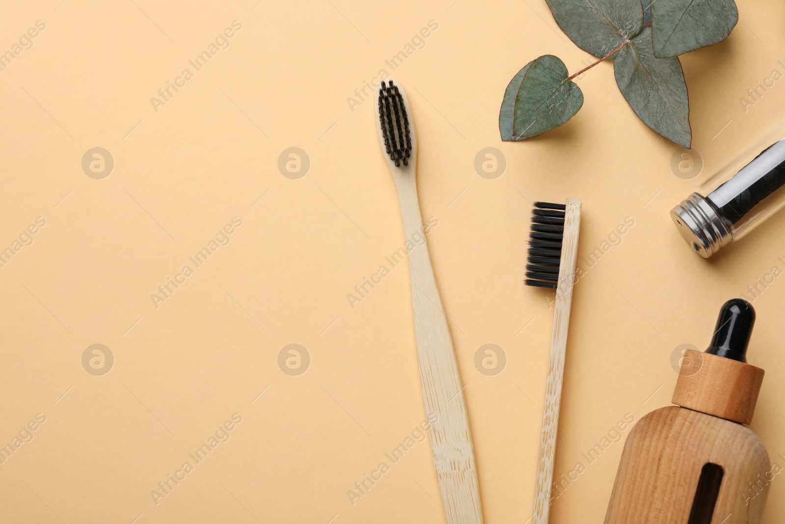 Photo of Flat lay composition with bamboo toothbrushes on pale orange background, space for text