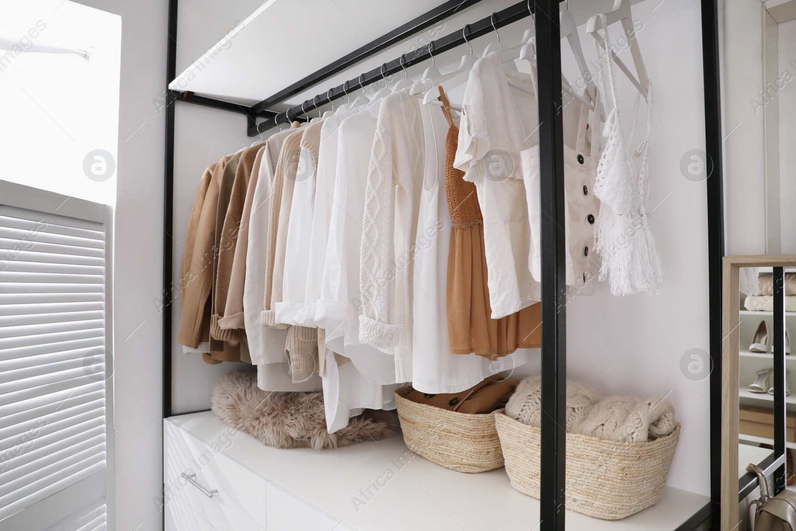 Photo of Rack with stylish women's clothes in dressing room