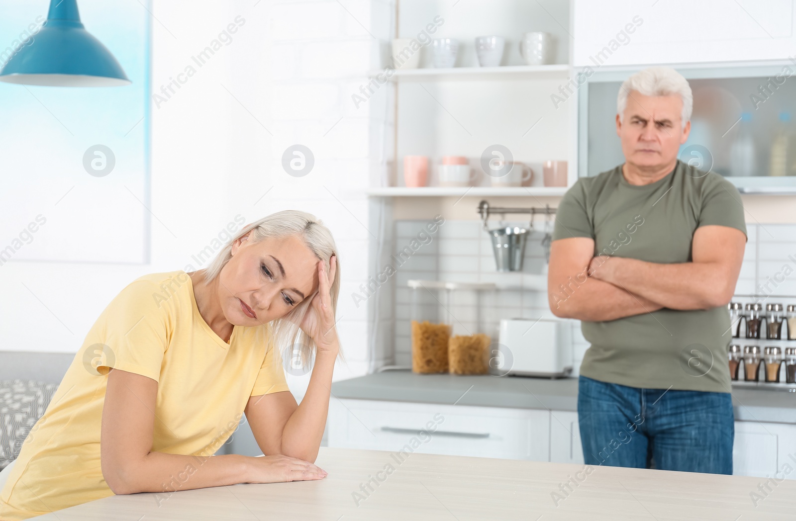 Photo of Mature couple arguing in kitchen. Relationship problems