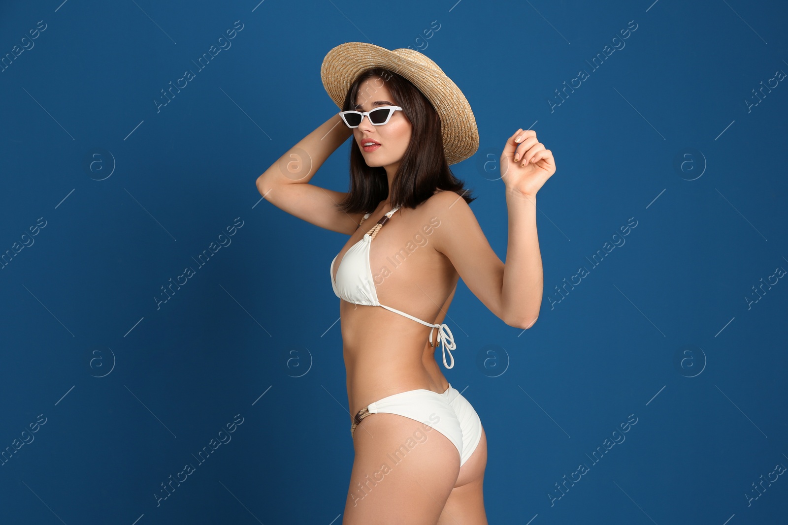 Photo of Beautiful woman in stylish bikini and sunglasses on blue background