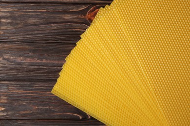 Photo of Natural beeswax sheets on wooden table, flat lay. Space for text