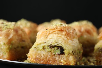 Photo of Delicious fresh baklava with chopped nuts on plate, closeup. Eastern sweets